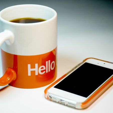 Coffee mug next to an Iphone